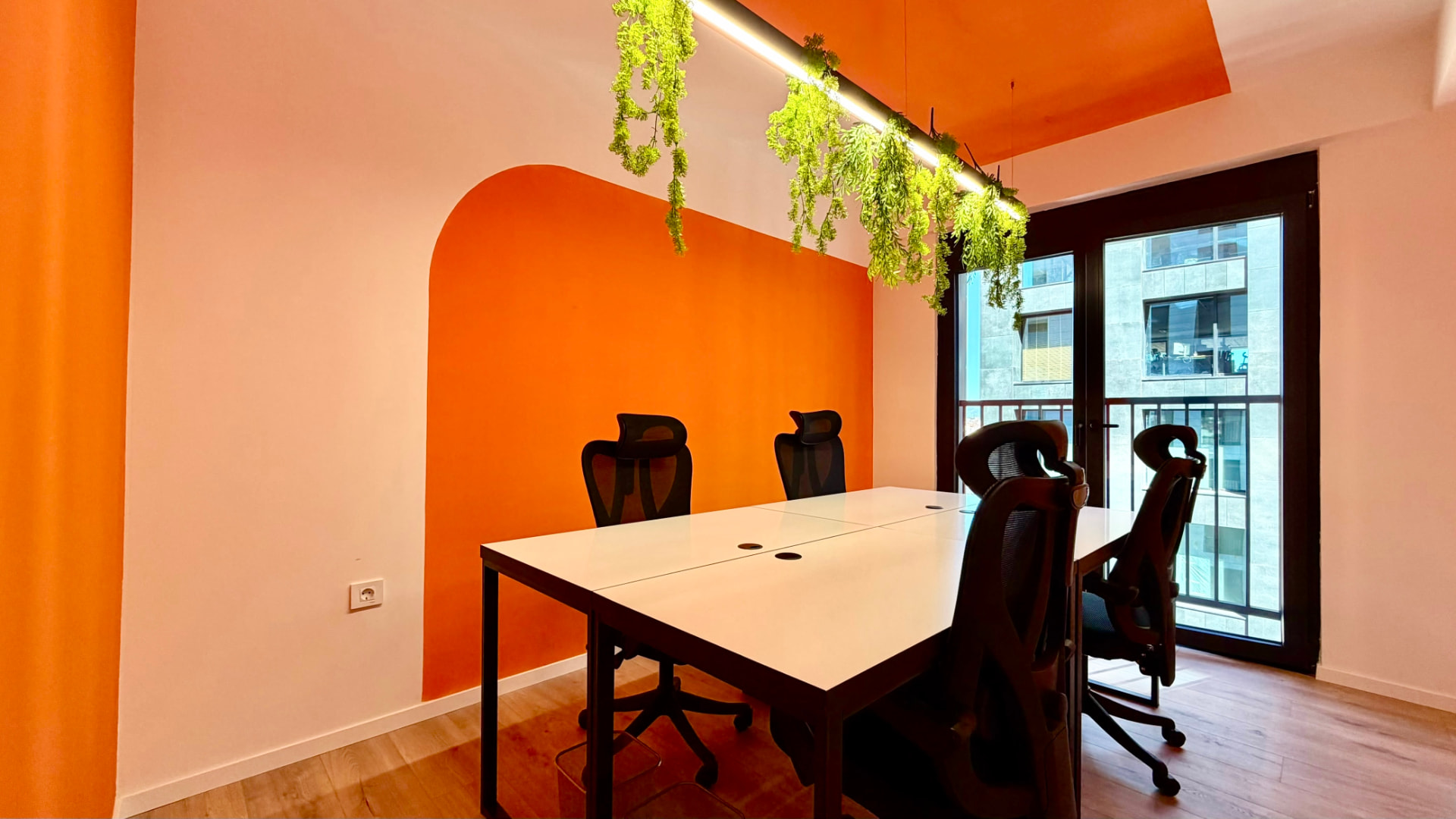 Private room with orange walls, hanging plants and a table for four